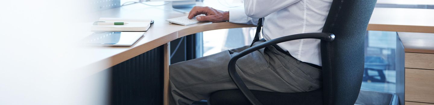 Büromitarbeiter sitzt an einem Schreibtisch mit Computer und telefoniert. Büromitarbeiter sitzt an einem Schreibtisch mit Computer und telefoniert.